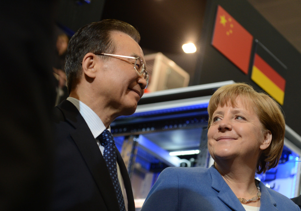 Federal Chancellor Merkel and Premier Wen stand underneath a German and a Chinese flag.