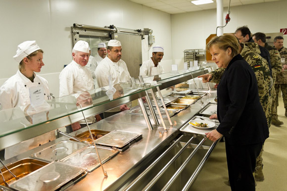Chancellor Angela Merkel talks to the cooks in the canteen.