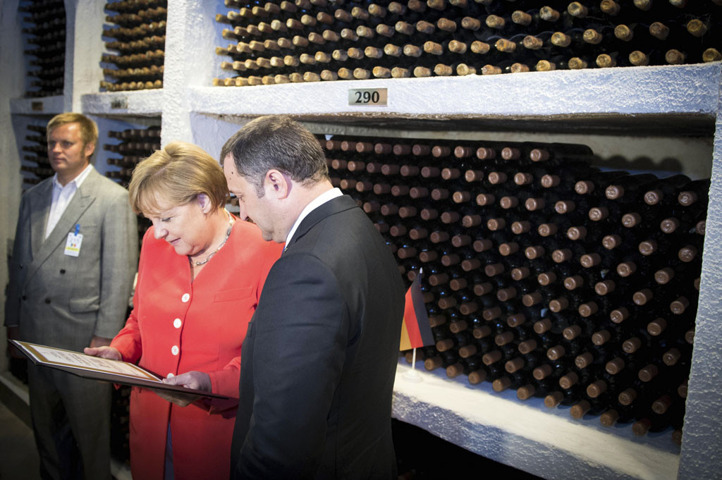 Angela Merkel and Prime Minister Vladimir Filat in front of a wine rack