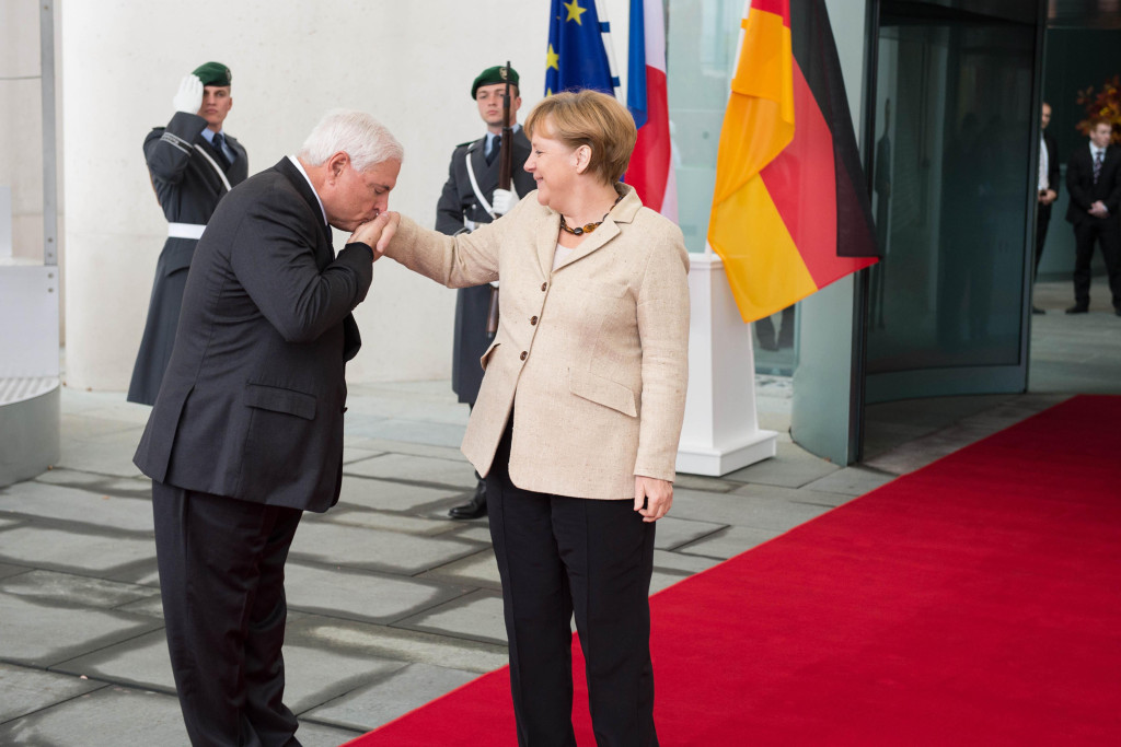 Ricardo Martinelli kisses Angela Merkel's hand.