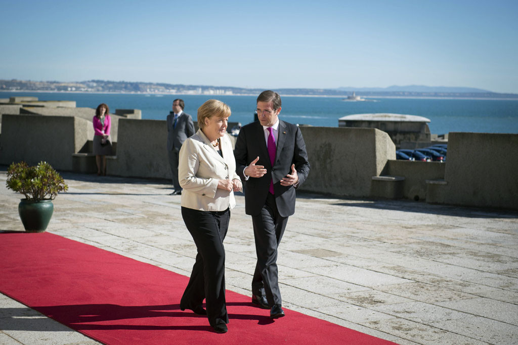 Angela Merkel is welcomed by Pedro Passos Coelho