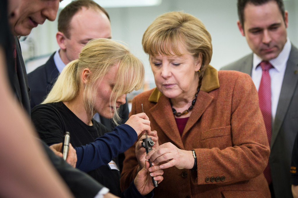 Angela Merkel and a staff member with an injector
