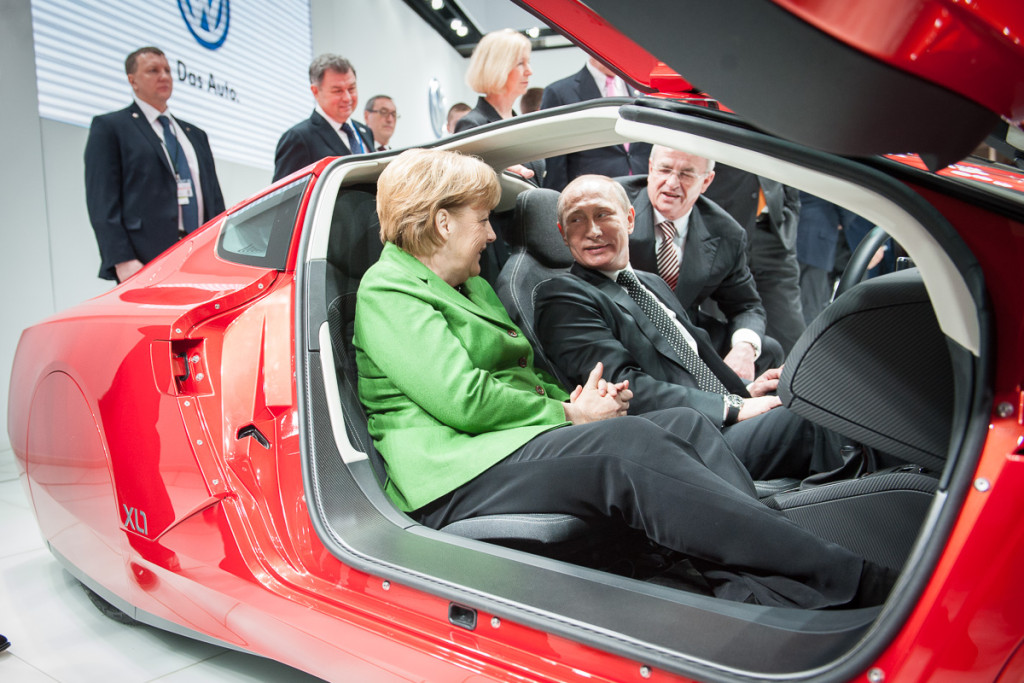 Angela Merkel and Vladimir Putin take their seats in the Volkswagen XL1.