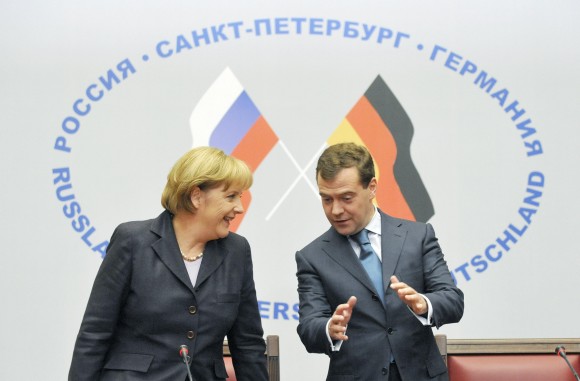 Chancellor Angela Merkel and President Dmitry Medvedev in discussion against a backdrop of the German and Russian flags