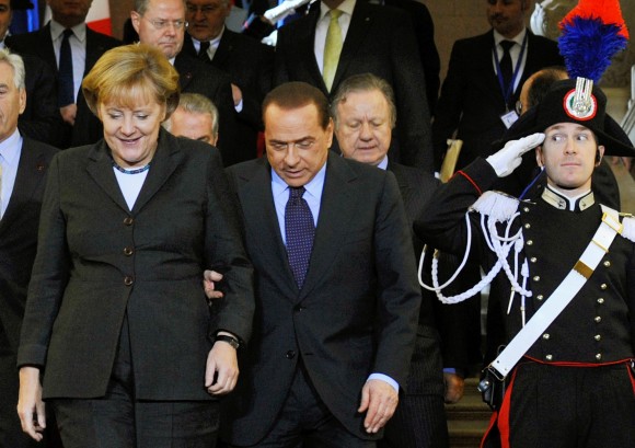 A carabinieri salutes as Chancellor Angela Merkel and Prime Minister Silvio Berlusconi arrive.