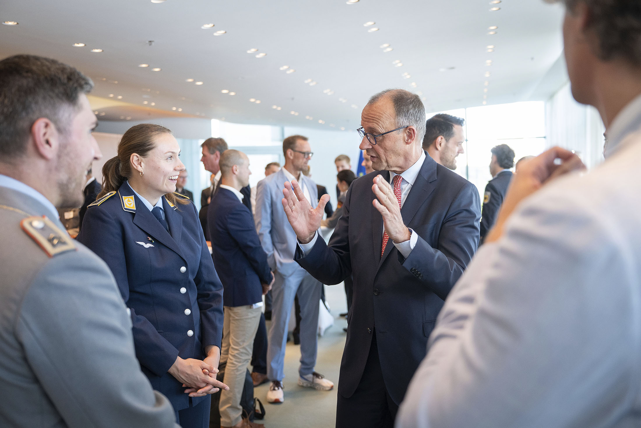 Bundeskanzler Friedrich Merz im Gespräch mit Sportlerinnen und Sportlern bei einem Empfang im Bundeskanzleramt.