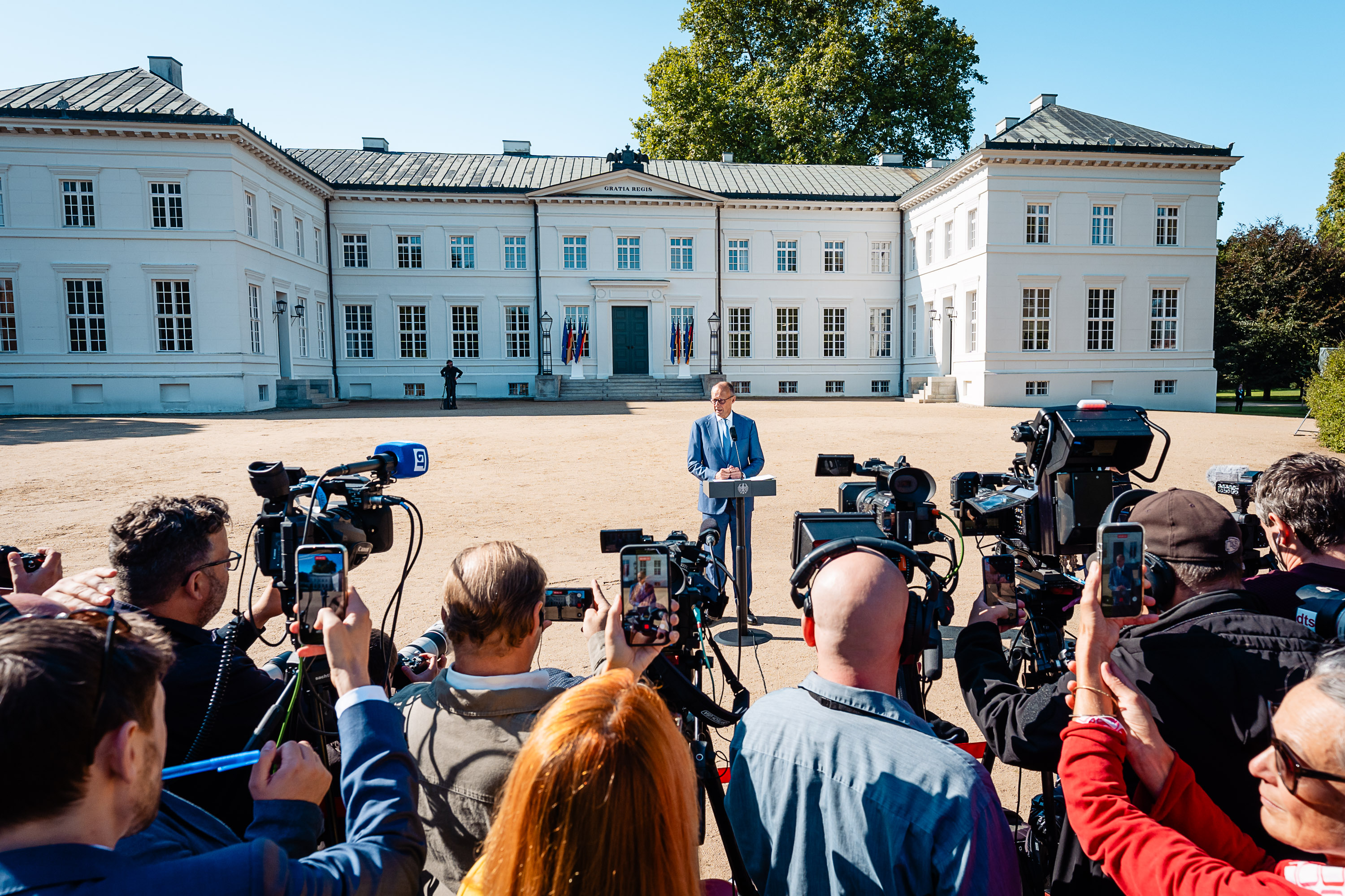 Vor dem Schloss Neuhardenberg gibt der Kanzler ein Pressestatement ab.