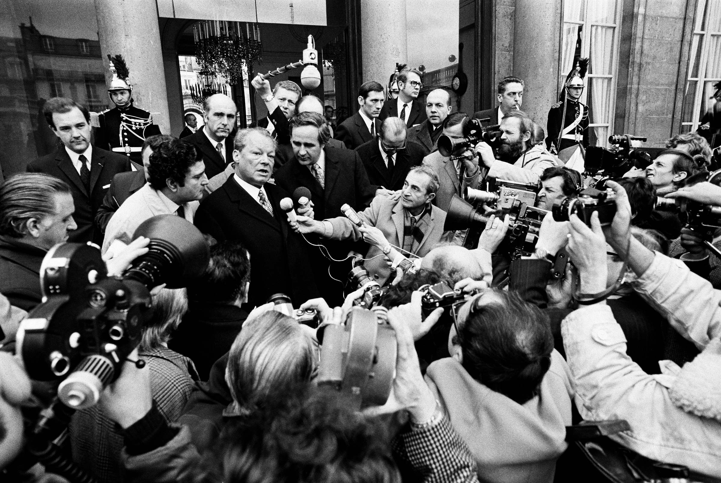 Schwarz-weiß-Fotografie aus dem Jahr 1971 zeigt Bundeskanzler Willy Brandt während eines Pressestatements vor dem Elysée-Palast.