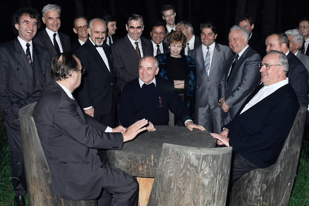 Bundeskanzler Helmut Kohl (r.), der Staatspräsident der UdSSR, Michail Gorbatschow (m.), und der Bundesminister des Auswärtigen, Hans-Dietrich Genscher, rasten während eines Spaziergangs an einem Holztisch in der Nähe der privaten Datscha Gorbatschows …