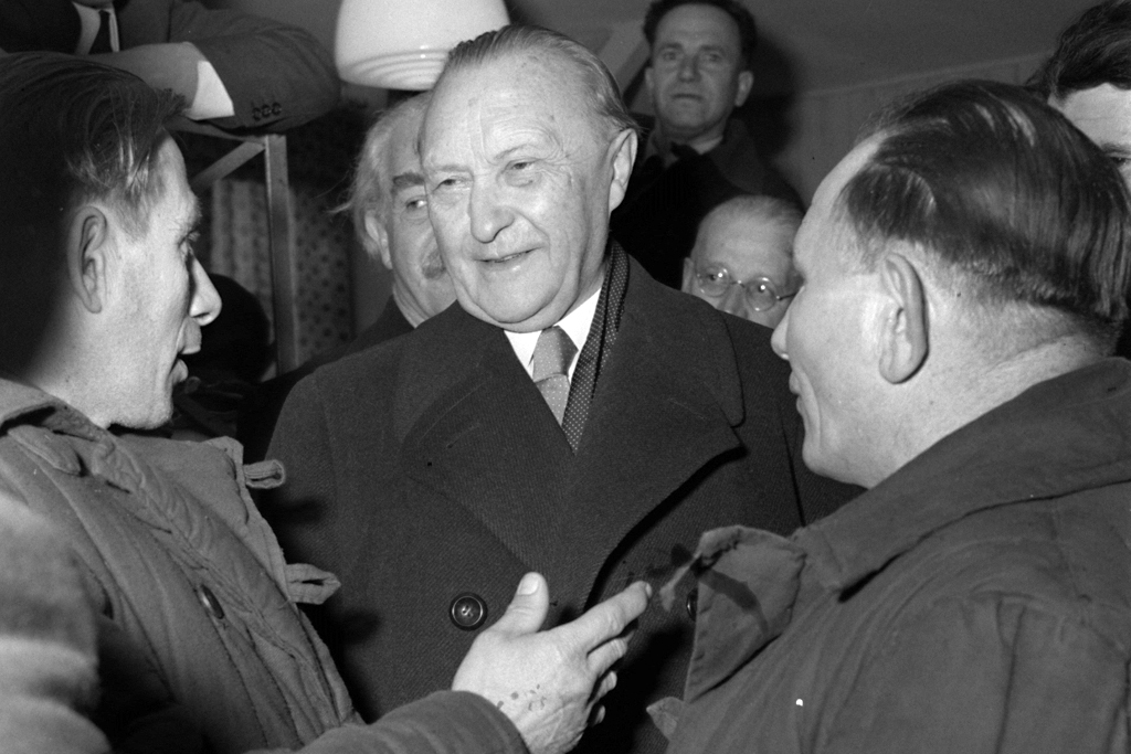 Bundeskanzler Konrad Adenauer (M.) im Gespräch mit Heimkehrern aus sowjetischer Kriegsgefangenschaft im Lager Friedland 1954