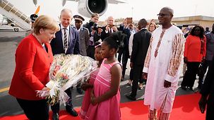 Bundeskanzlerin Angela Merkel wird bei der Ankunft in Burkina Faso mit Blumen empfangen.