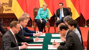 Bundeskanzlerin Angela Merkel und Li Keqiang, Chinas Premierminister, verfolgen Vertragsunterzeichnungen.