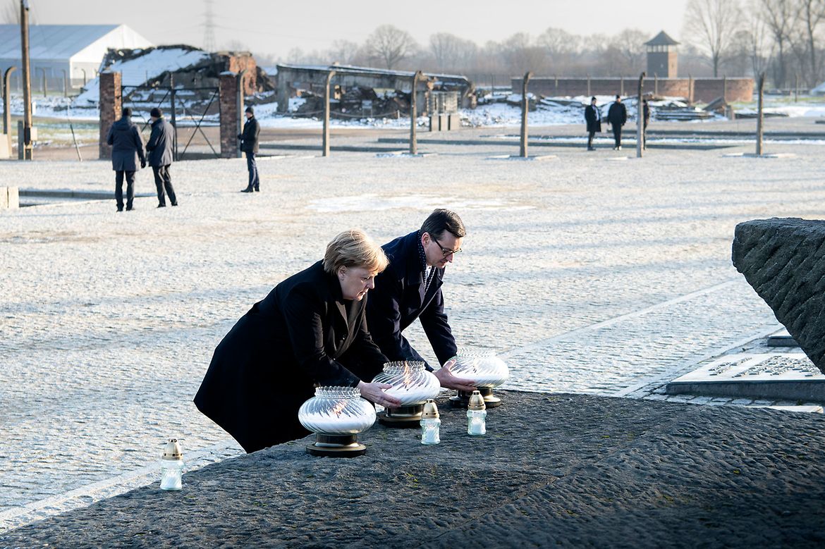 Die Kanzlerin entzündet eine Kerze in der Gedenkstätte des ehemaligen Konzentrationslager Auschwitz.