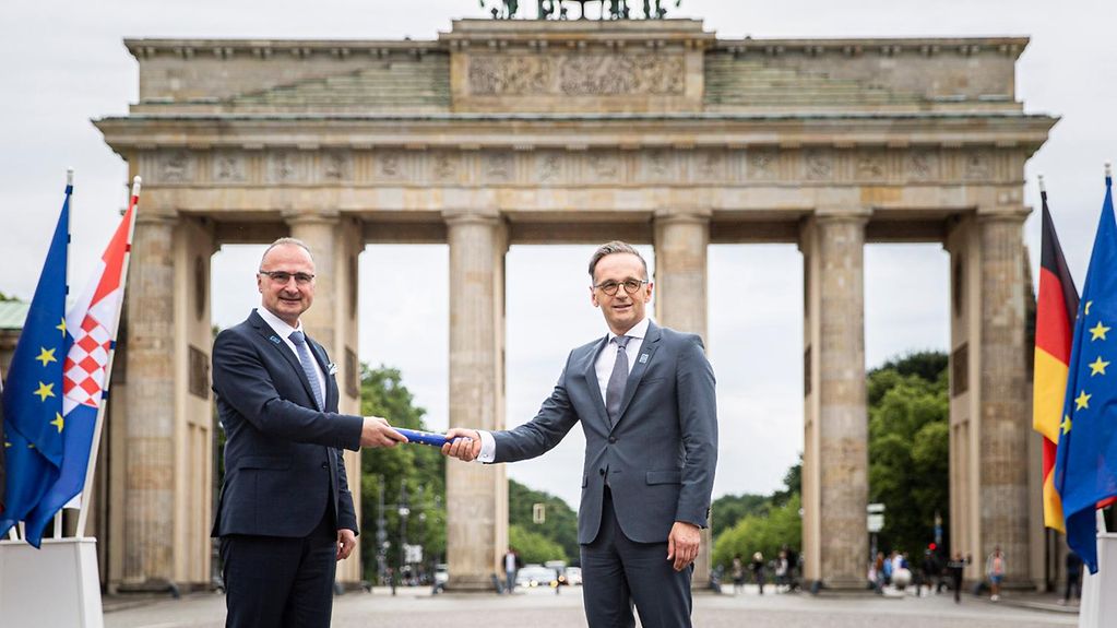 At the Brandenburg Gate, Federal Minister for Foreign Affairs Heiko Maas (at right) is handed the symbolic baton by his Croatian counterpart Gordan Grlić Radmann.