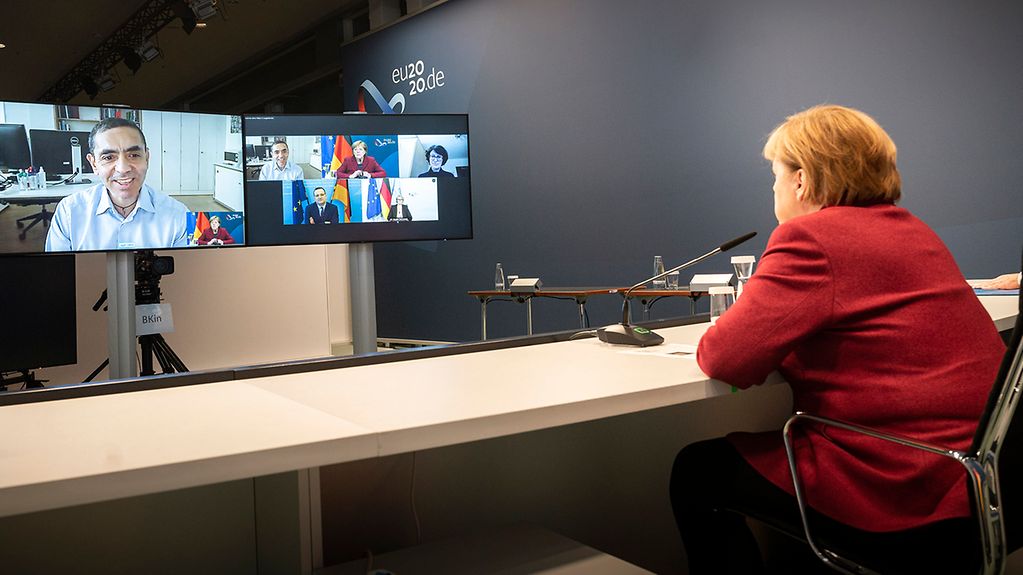 Chancellor Angela Merkel talks to Uğur Şahin, founder of the vaccine company BioNTech.