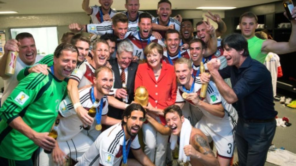 Bundeskanzlerin Angela Merkel und Bundespräsident Joachim Gauck (beide M.) mit der deutschen Mannschaft nach dem gewonnenen Fußball-WM-Endspiel in der Kabine im Maracana Stadion (r. Bundestrainer Joachim Löw).