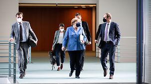 Chancellor Angela Merkel walks through the Federal Chancellery next to Michael Müller, Berlin's Governing Mayor.