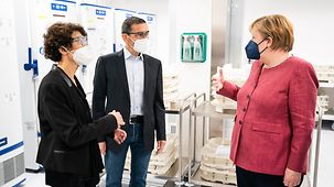 Bundeskanzlerin Angela Merkel beim Besuch der Biontech Impftoffproduktion im Gesrpäch mit den Biontech-Gründern Ugur Sahin und Özlem Türeci.