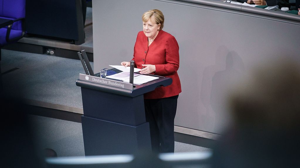 Federal Chancellor Merkel at the lectern on the floor of the Bundestag.