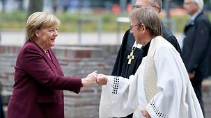 Bundeskanzlerin Angela Merkel bei der Ankunft zu einem ökumenischen Gottesdienst mit Karl Jüsten, Leiter des Katholischen Büros des Kommissariats der deutschen Bischöfe.
