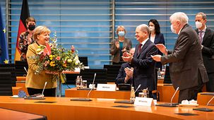 Bundeskanzlerin Merkel während der 161. Kabinettssitzung der laufenden Legislaturperiode mit einem Blumenstrauß, der ihr von Vizekanzler Scholz überreicht wurde.