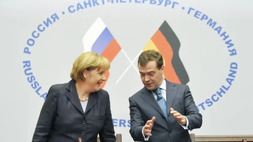 Chancellor Angela Merkel and President Dmitry Medvedev in discussion against a backdrop of the German and Russian flags