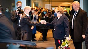 Federal Chancellor Angela Merkel takes leave of Federal Chancellor Olaf Scholz.