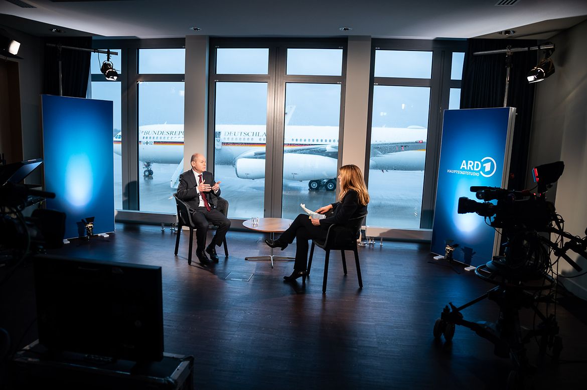 Federal Chancellor Olaf Scholz being interviewed by presenter Tina Hassel at the airport.
