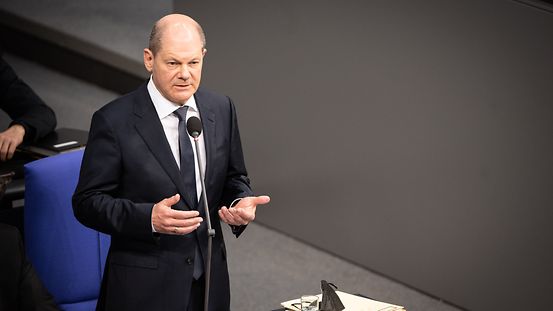 Bundeskanzler Scholz spricht von seinem Platz aus zum Bundestag.