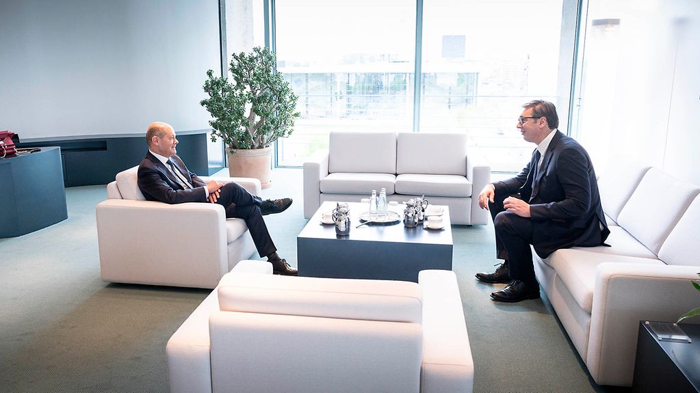 Das Bild zeigt Kanzler Scholz und Präsident Vučić. Sie sitzen auf weißen Sesseln im Bundeskanzleramt.