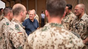 Bundeskanzler Olaf Scholz beim Besuch des Bundeswehrstützpunktes in Tillia im Gespräch mit Soldaten.