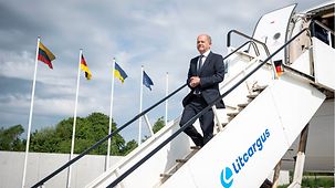 Bundeskanzler Olaf Scholz geht bei der Ankunft auf dem Flughafen in Litauen die Gangway hinunter.