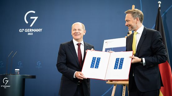 Bundeskanzler Olaf Scholz und Christian Lindner, Bundesminister der Finanzen, präsentieren die Sonderbriefmarke zum G7-Gipfel.