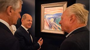 Bundeskanzler Olaf Scholz neben "Der Schrei" im Munch-Museum.