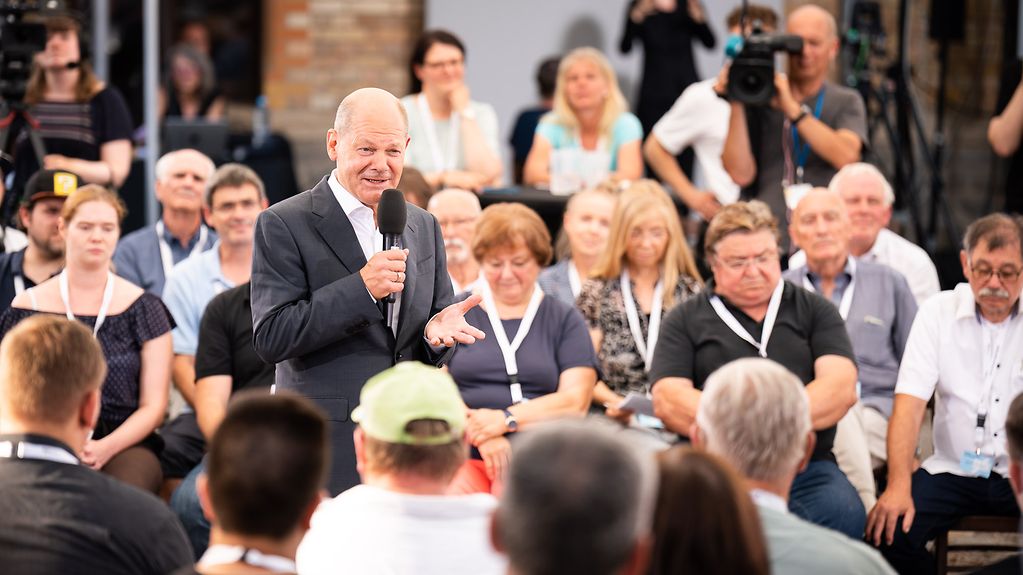 Federal Chancellor Olaf Scholz talking to members of the public.