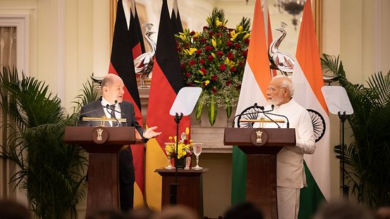 Bundeskanzler Scholz gibt mit dem indischen Premierminister ein Pressekonferenz. Sie stehen vor ihren Landesflaggen an Rednerpulten.