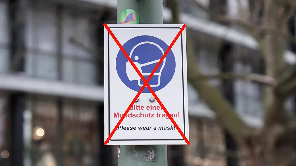 Durchgestrichenes Hinweis-Schild, dass ein Mund-Schutz getragen werden muss
