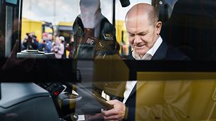 Bundeskanzler Olaf Scholz beim Besuch eines Betriebshof der Berliner Verkehrsbetriebe in einem E-Bus.
