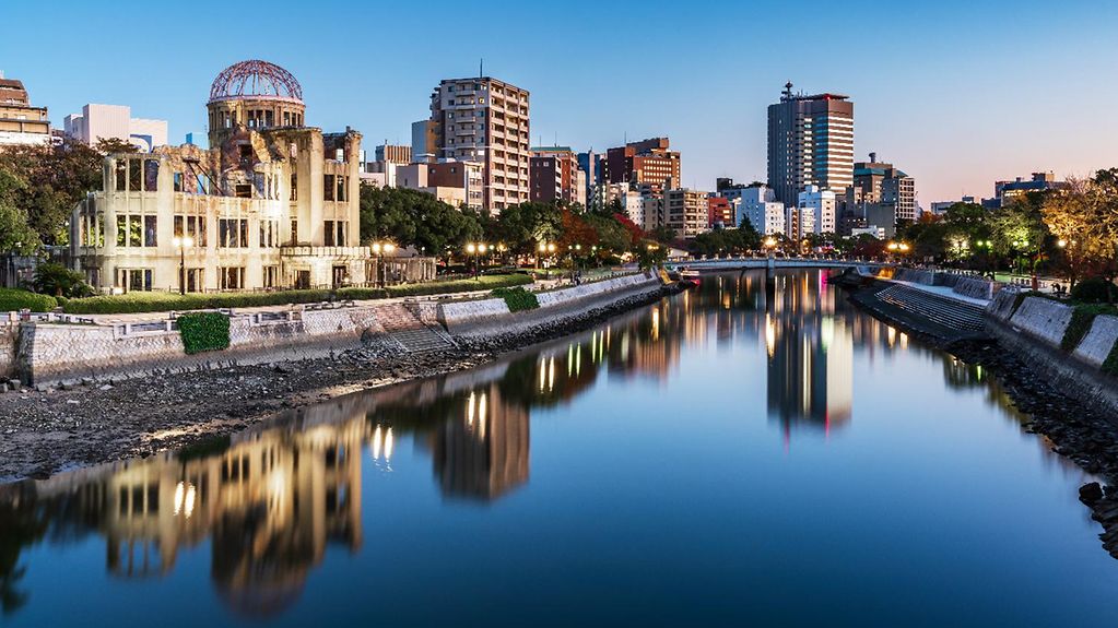 Der Fluss Ōta in der Dämmerung vor dem Stadtbild Hiroshimas.