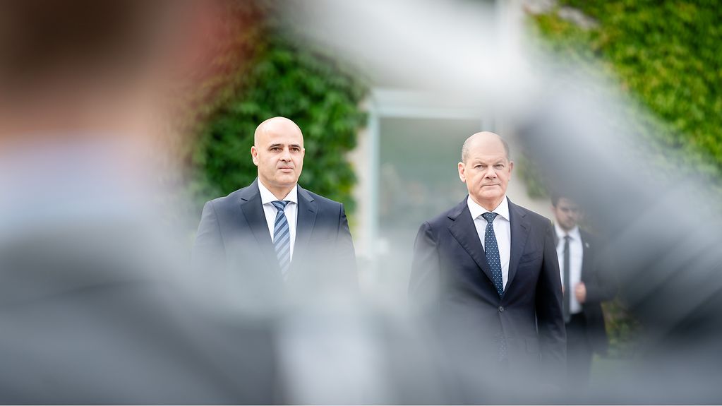 Bundeskanzler Olaf Scholz und Ministerpräsidenten von Nordmazedonien Dimitar Kovacevski vor dem Bundeskanzleramt. Im Vordergrund ein salutierender Soldat.