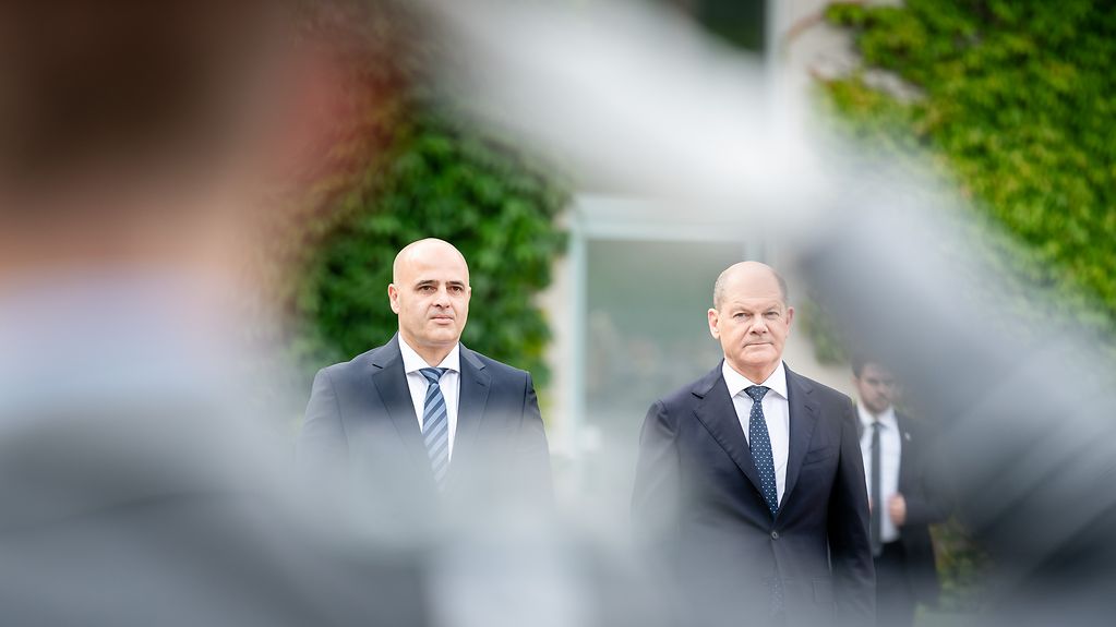Federal Chancellor Olaf Scholz and Dimitar Kovacevski, Prime Minister of North Macedonia, outside the Chancellery. A soldier salutes in the foreground.