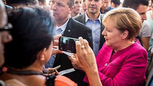 Bundeskanzlerin Angela Merkel schreibt ein Autogramm.
