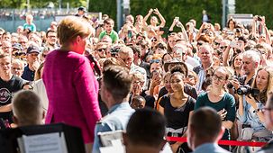 Bundeskanzlerin Angela Merkel spricht auf einer Bühne im Ehrenhof des Kanzleramtes.