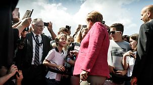 Bundeskanzlerin Angela Merkel im Gespräch mit einem kleinen Jungen.