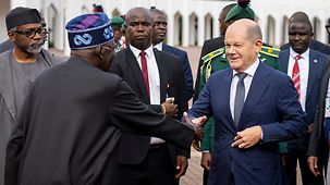 Bundeskanzler Olaf Scholz wird in Nigeria von Präsident Bola Ahmed Tinubu begrüßt.