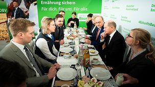 Bundeskanzler Scholz im Gespräch mit jungen Landwirtinnen und Landwirten auf der Grünen Woche.