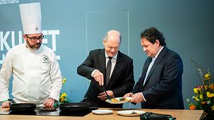 Bundeskanzler serviert Pancakes in einer Showküche während des Besuch der Grünen Woche.