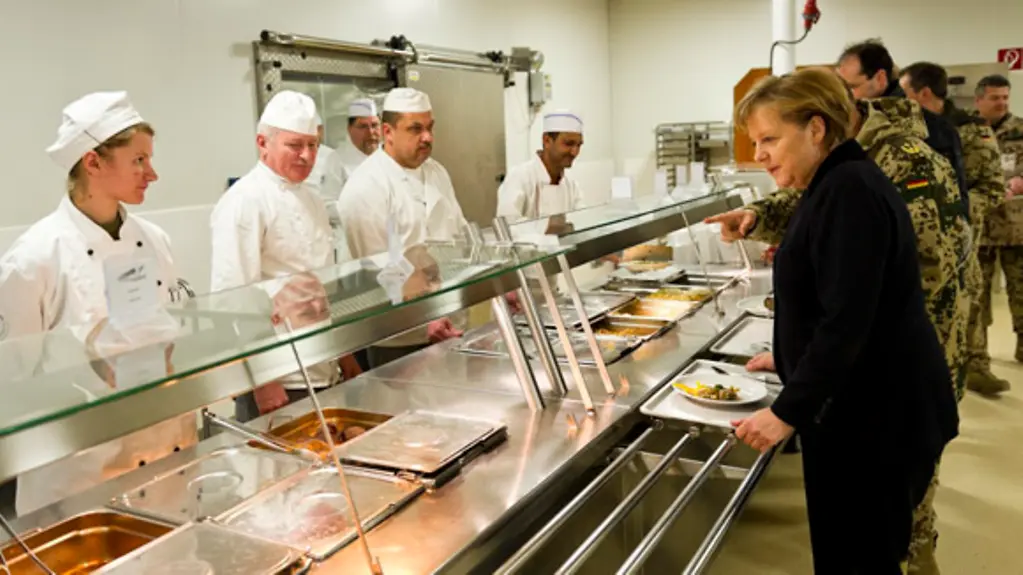 Chancellor Angela Merkel talks to the cooks in the canteen.