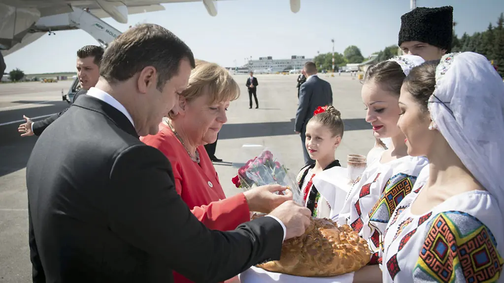 Young women in traditional costume present the Chancellor with bread.