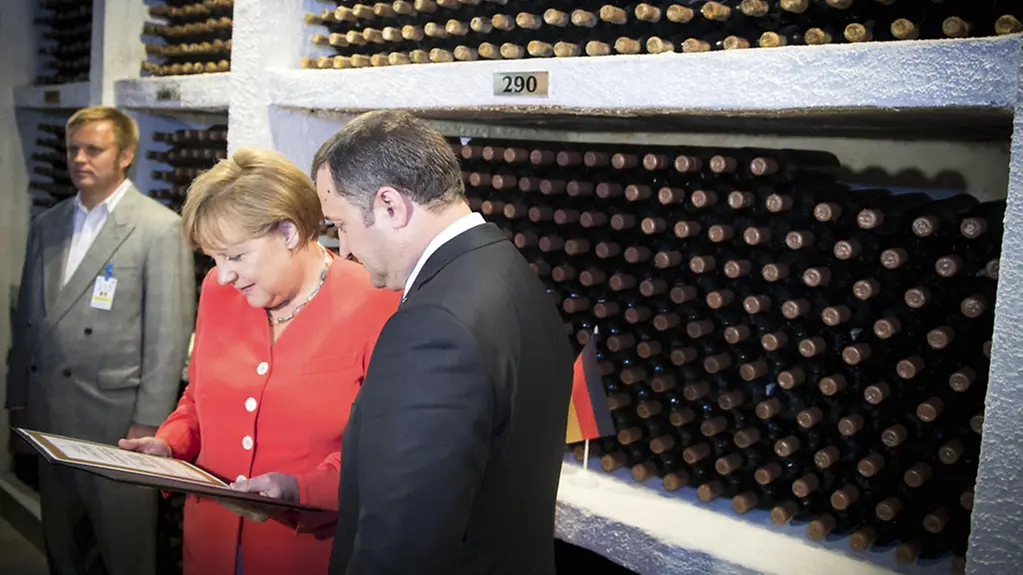 Angela Merkel and Prime Minister Vladimir Filat in front of a wine rack